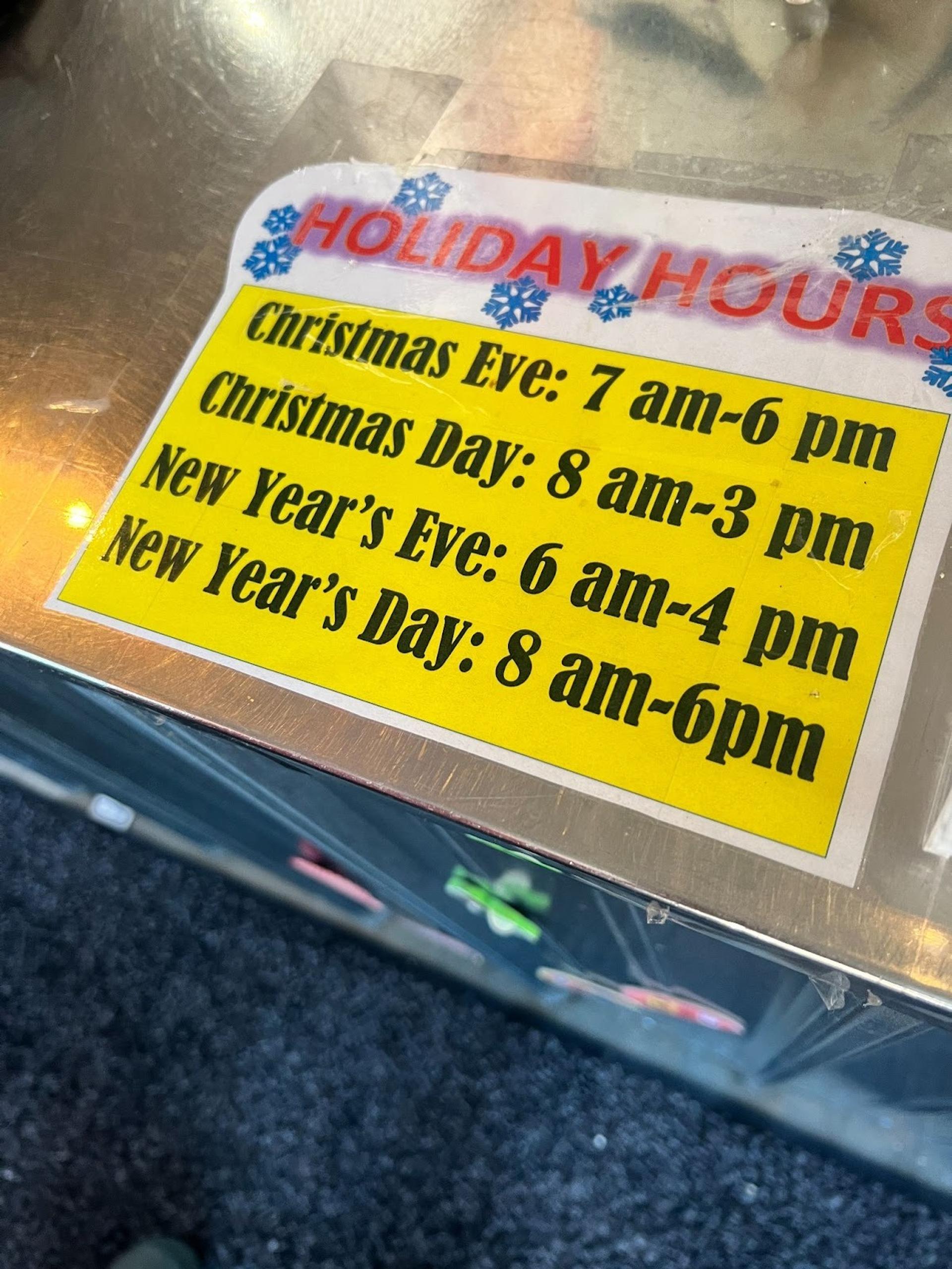 A sign listing holiday hours on a counter
