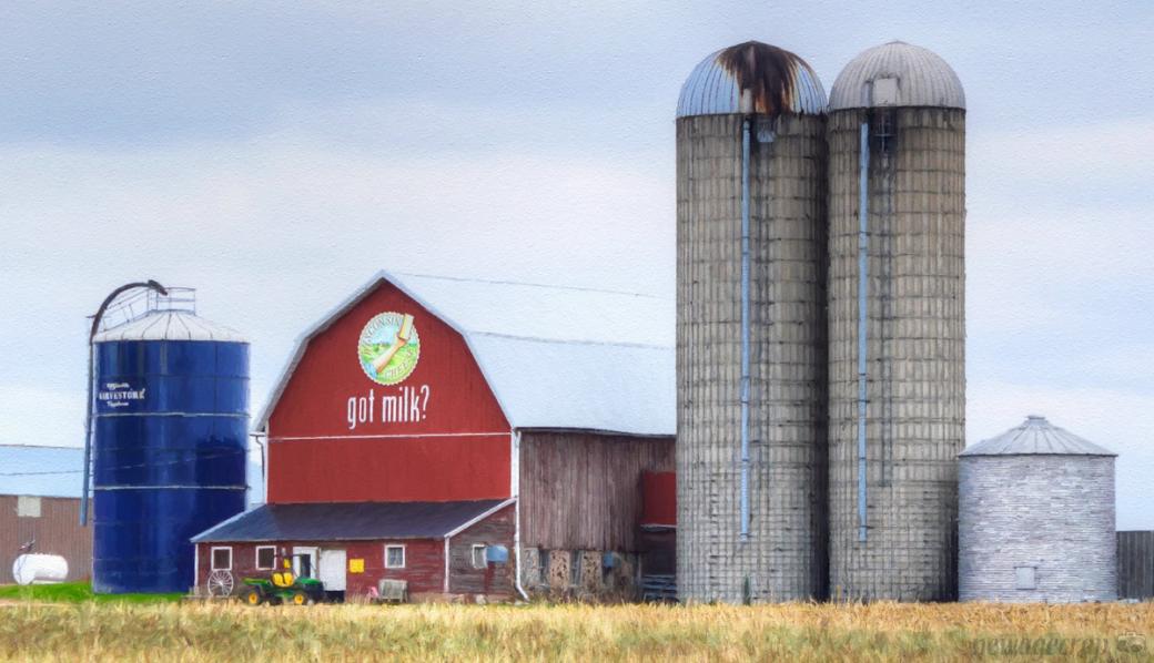 A red barn that reads "got milk?" and several silos.