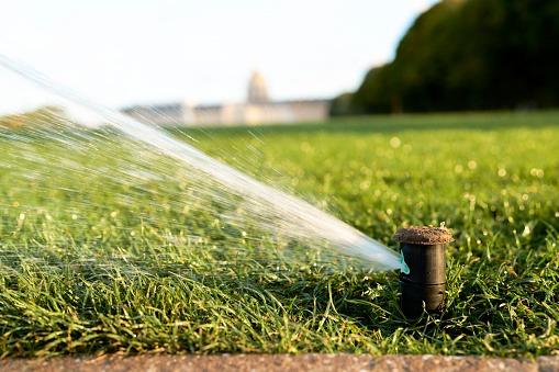Nozzle of an irrigation system spraying the grass with water