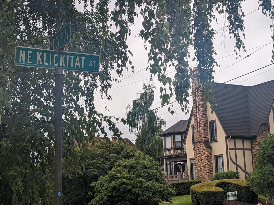 street sign with large house in background