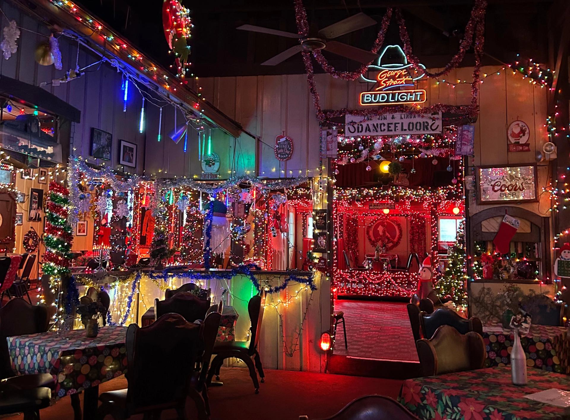 A dark bar covered in Christmas lights.