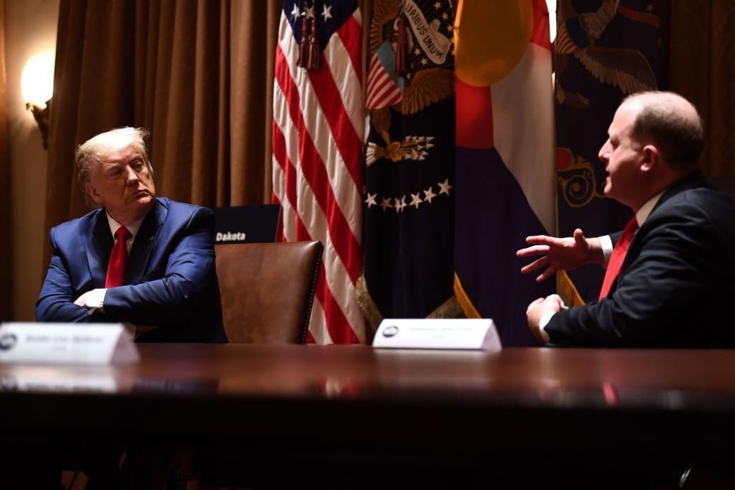 Two people sit at table discussing politics