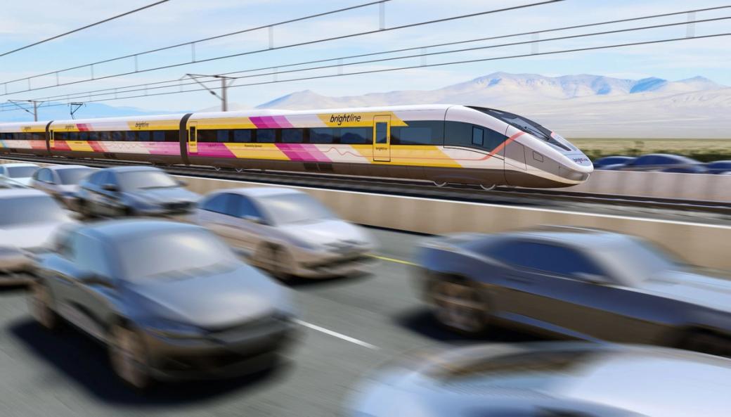A yellow, pink and white high speed train zooms down the track along a highway.