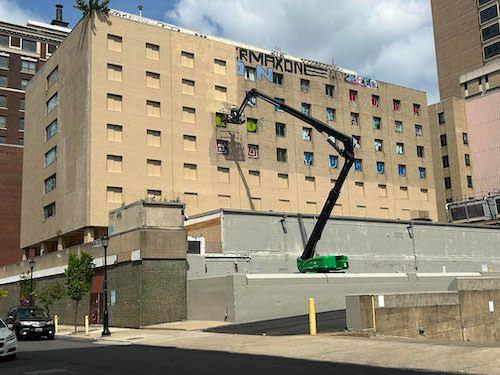 City workers covering up graffiti on a building in Center City. (Brittany Valentine/City Cast Philly)