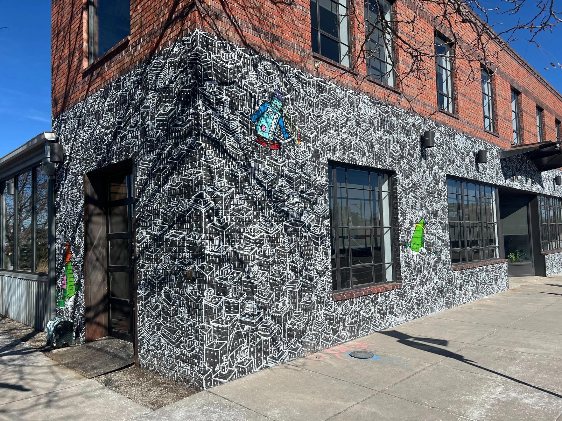 A Chris Haven mural wrapping around a building at 3001 Larimer Street.