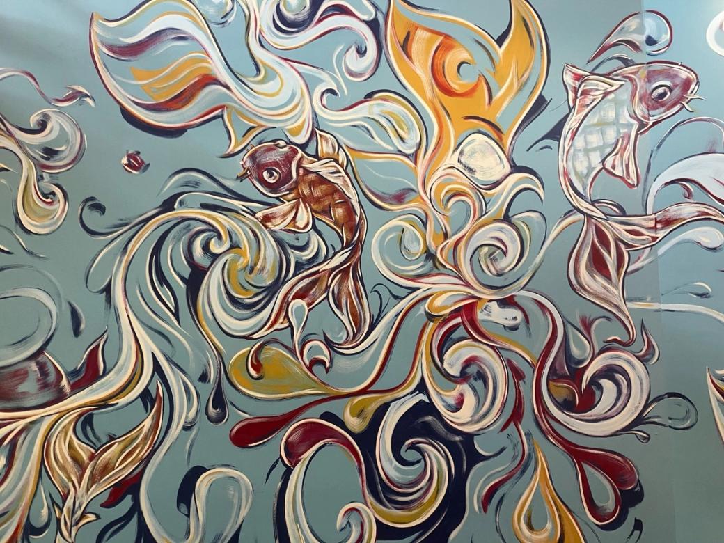 A mural of fish on a cornflower-colored wall.