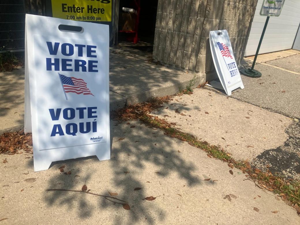 Two signs saying “Vote” outside of a doorway.