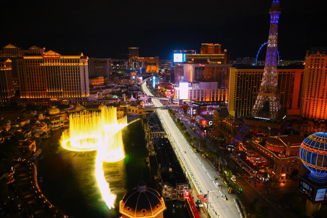 An aerial view of the Las Vegas Strip showing Las Vegas Blvd ad The Bellagio Fountains lit up at night.
