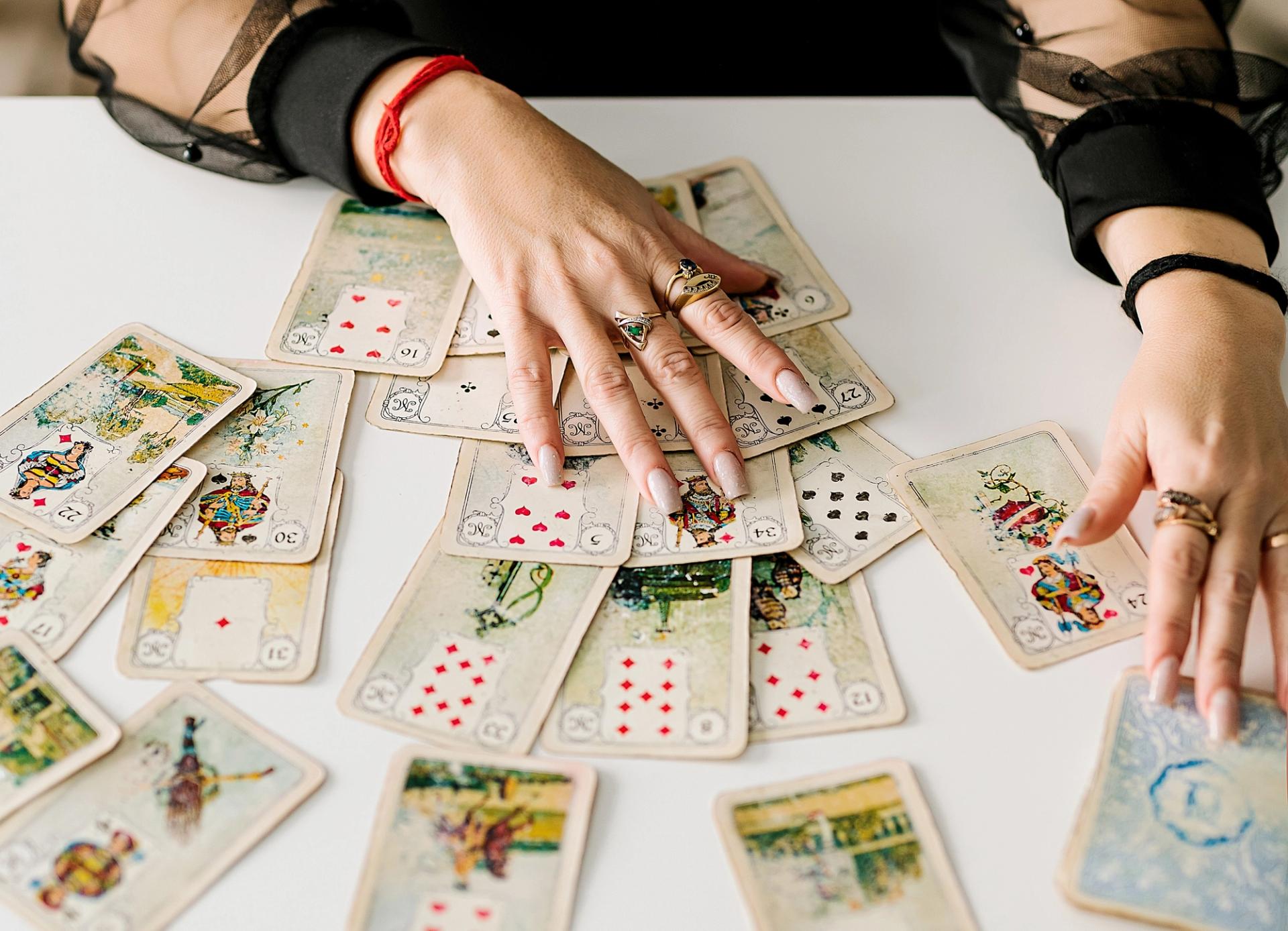 A fortune-teller makes predictions with tarot cards in hands