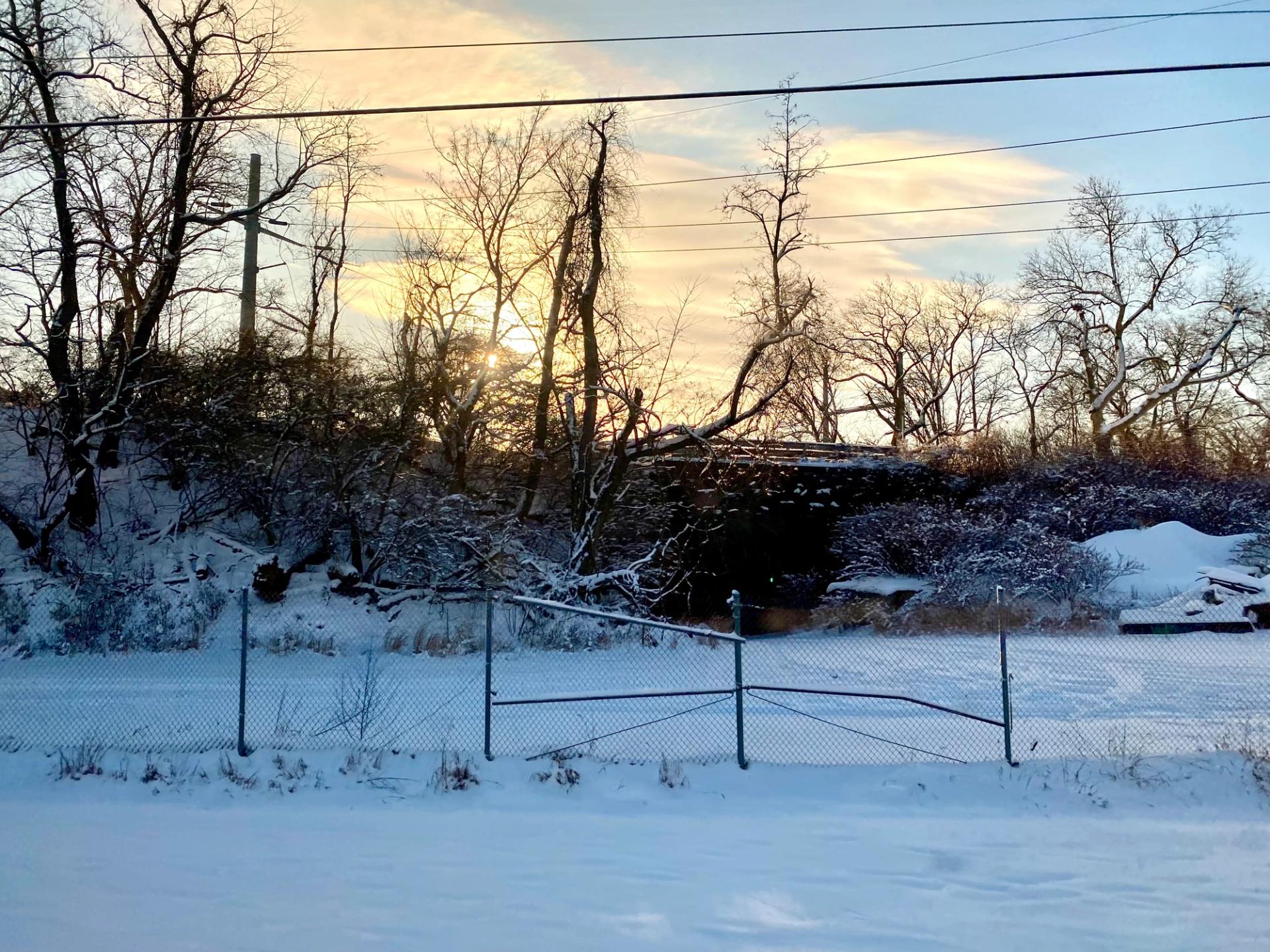 A snowy landscape around sunrise.