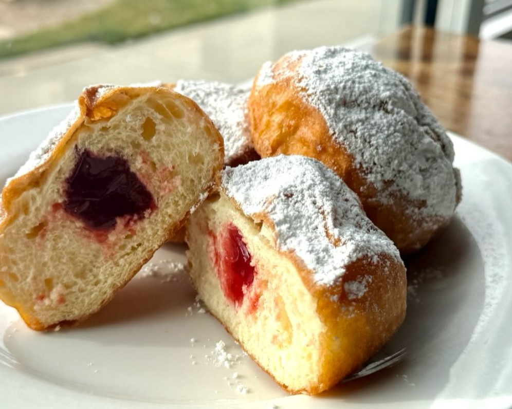 Jelly donuts on a white plate.