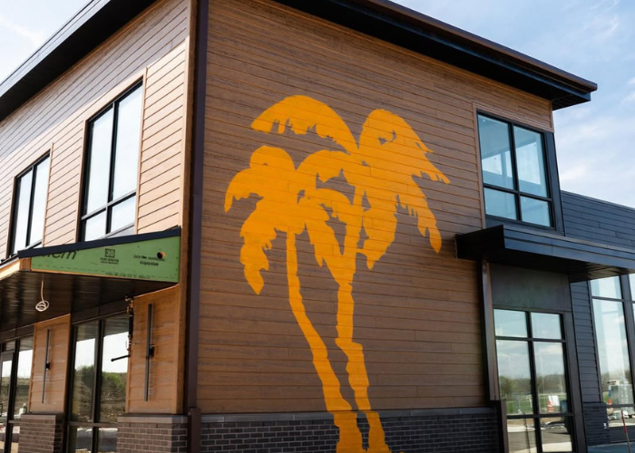 A wooden building with an orange outline of two palm trees.