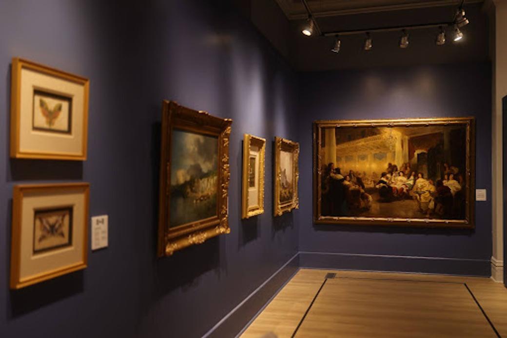 Paintings on blue gallery walls inside  the Salt Lake Art Museum. (Salt Lake Art Museum)