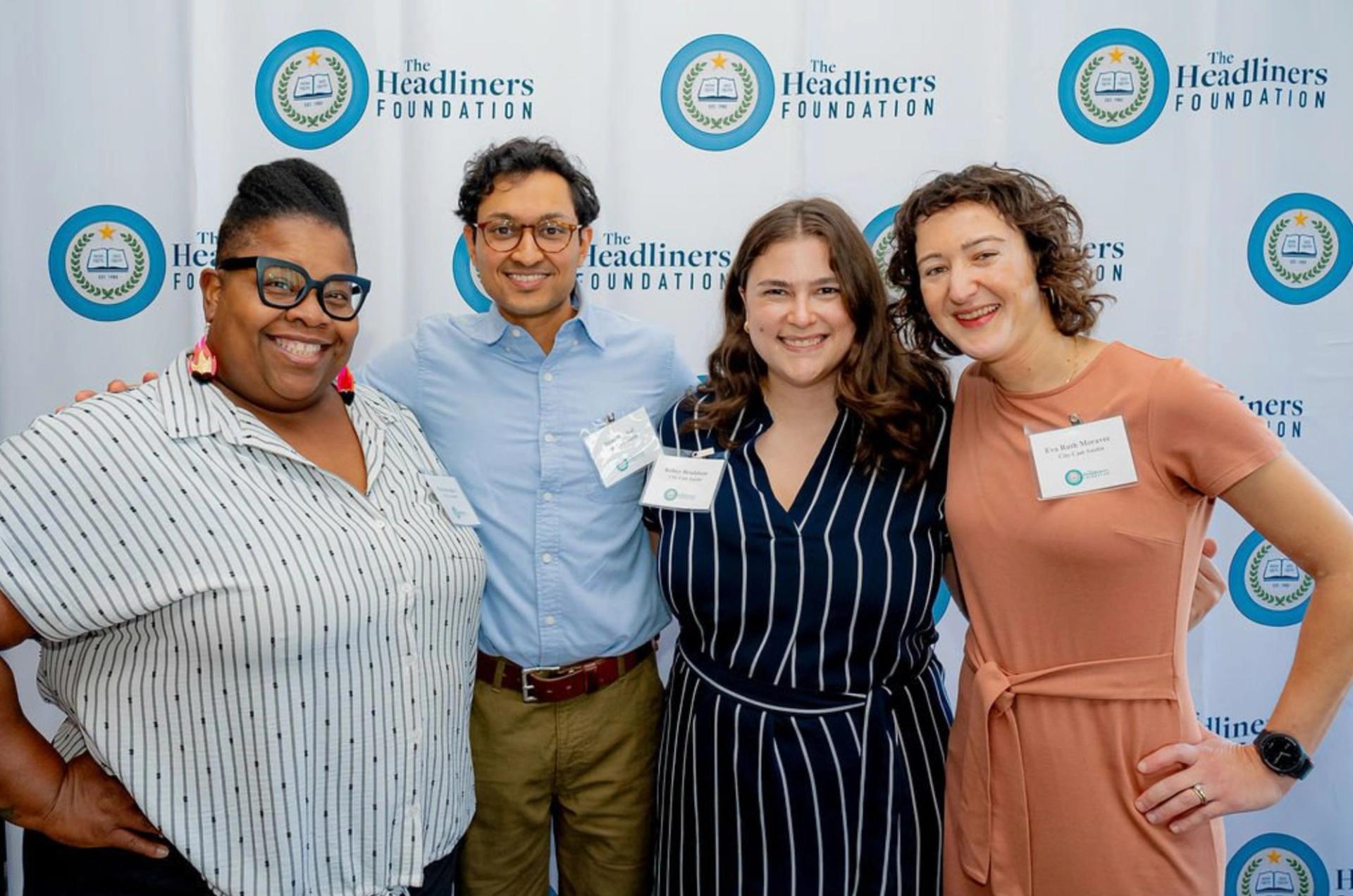 Four people sanding side by side and smiling.