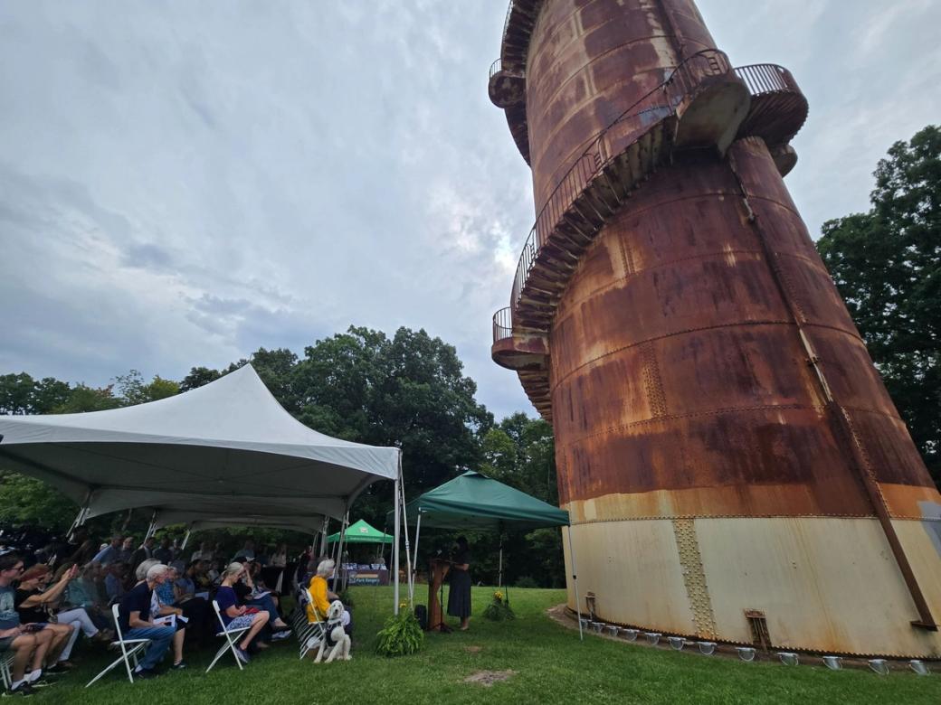 Allegheny County Executive Sara Innamorato speaks to a crowd in front of the rusty North Park Observation Tower.