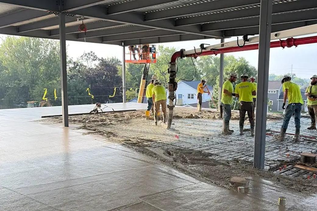 Workers in yellow shirts on a construction site.