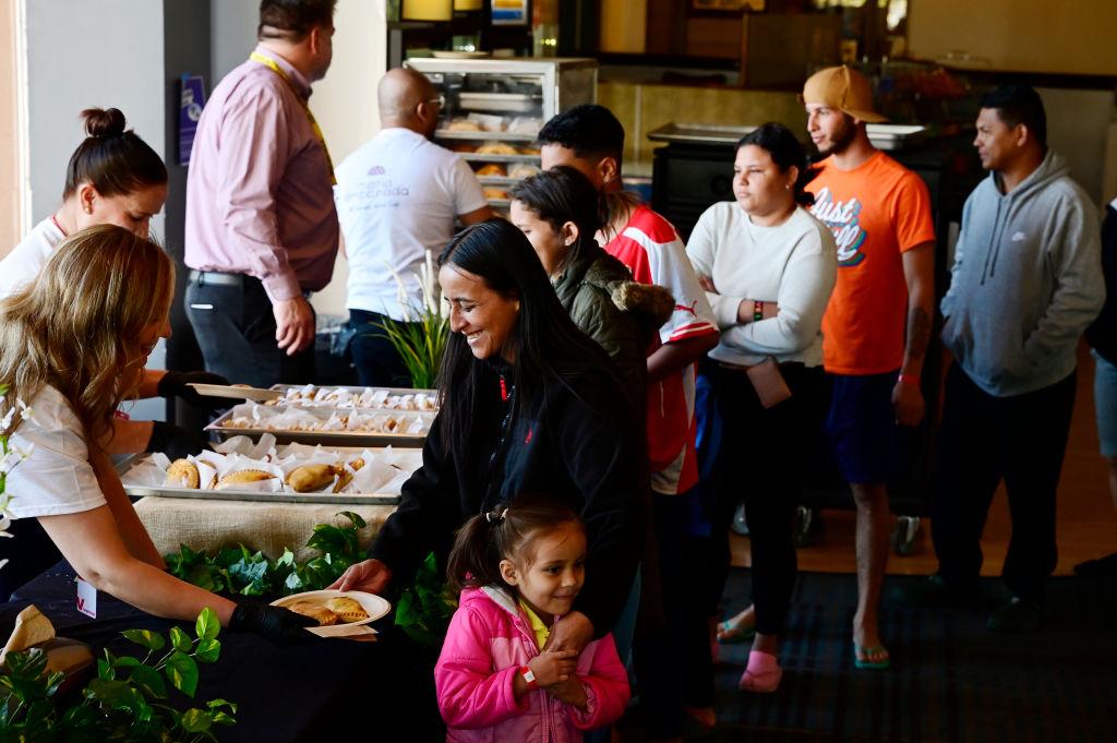 Maria Empanada employees serve empanadas to Venezuelan families on May 7, 2024.