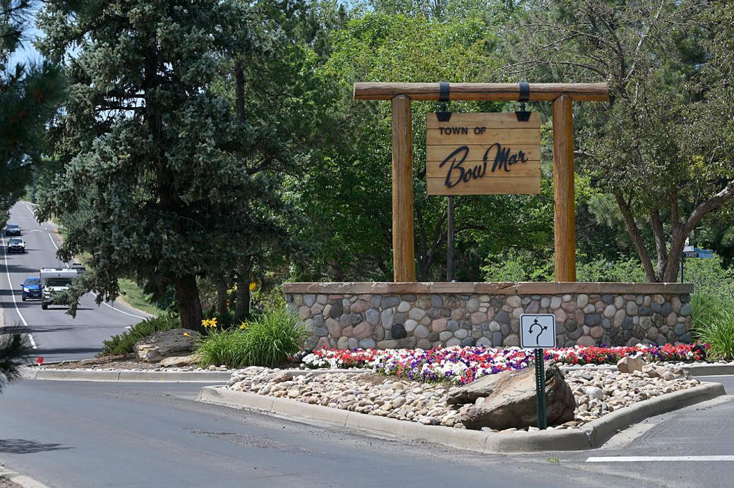  A large wooden sign on the side of a road reads “Town of Bow Mar.”