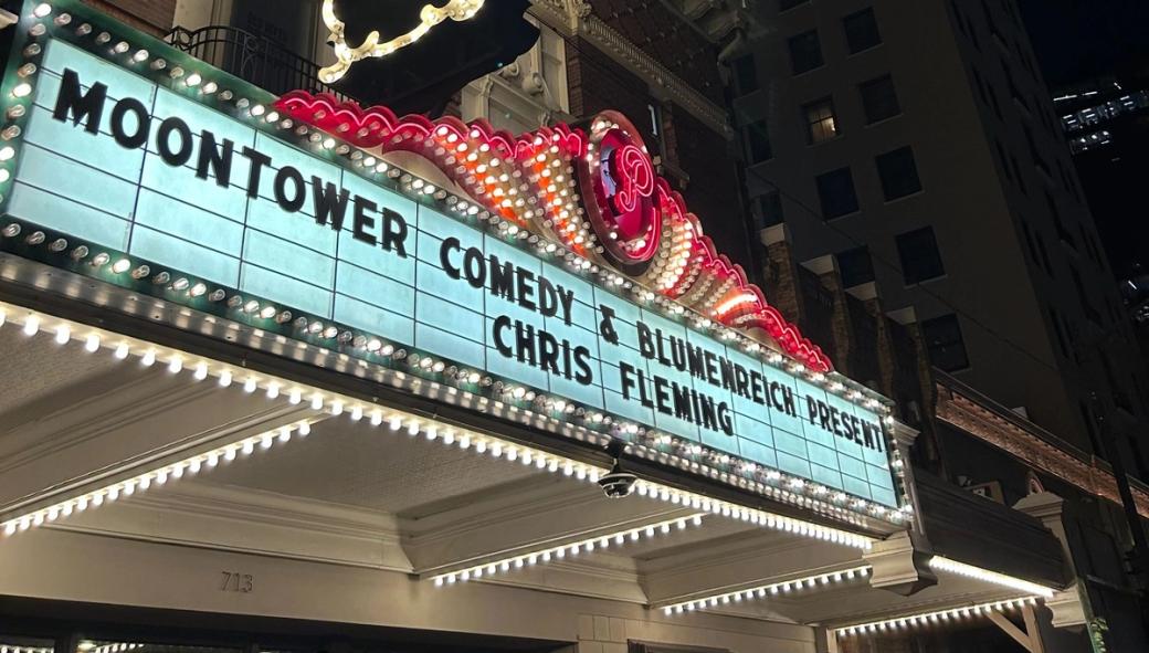 The Paramount Theatre in Austin's marquee at night reading, "Moontower Comedy & Blumewrench Present: Chris Fleming."