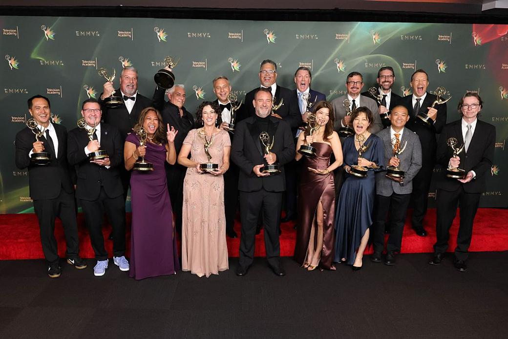 Group of people stand with their awards on the red carpet at the Emmy awards 