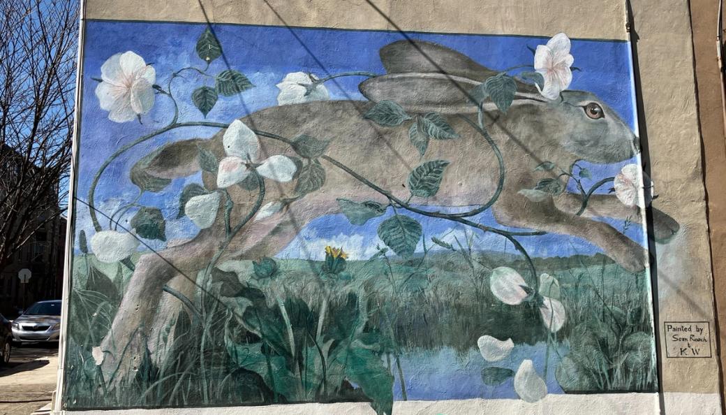 A mural of a rabbit hopping in the grass