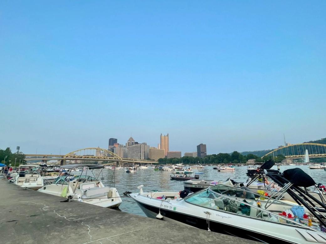 View of boats on a river. A downtown skyline in the background.