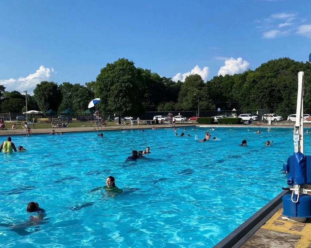 A clear summer day with people scattered across the pool.