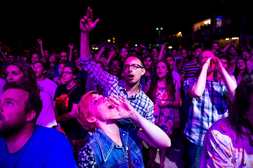 A crowd of people cheers during a live show at the 2014 Underground Music Showcase on South Broadway.