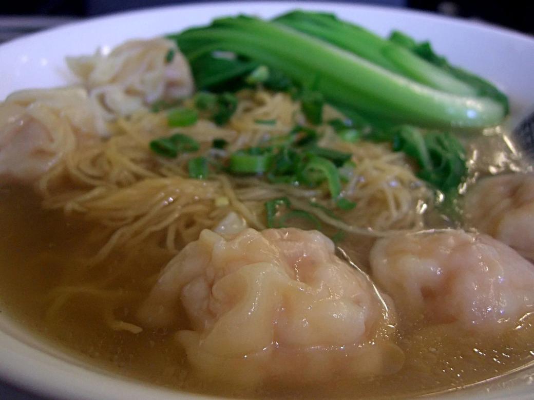 A white bowl filled with wonton noodle soup.