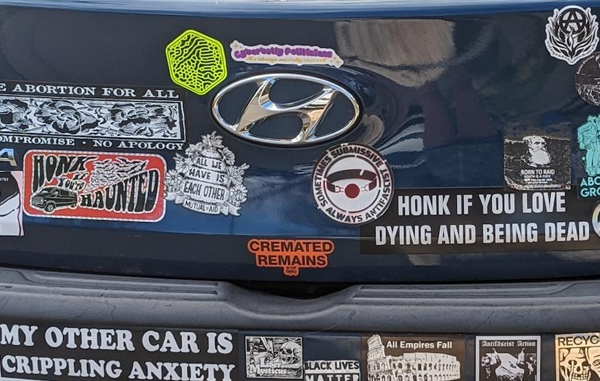 The back of blue Honda with a lot of bumper stickers