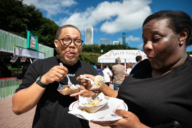 People eat Korean chili chicken bites and sour dumplings during the Taste of Chicago in downtown Chicago in 2023