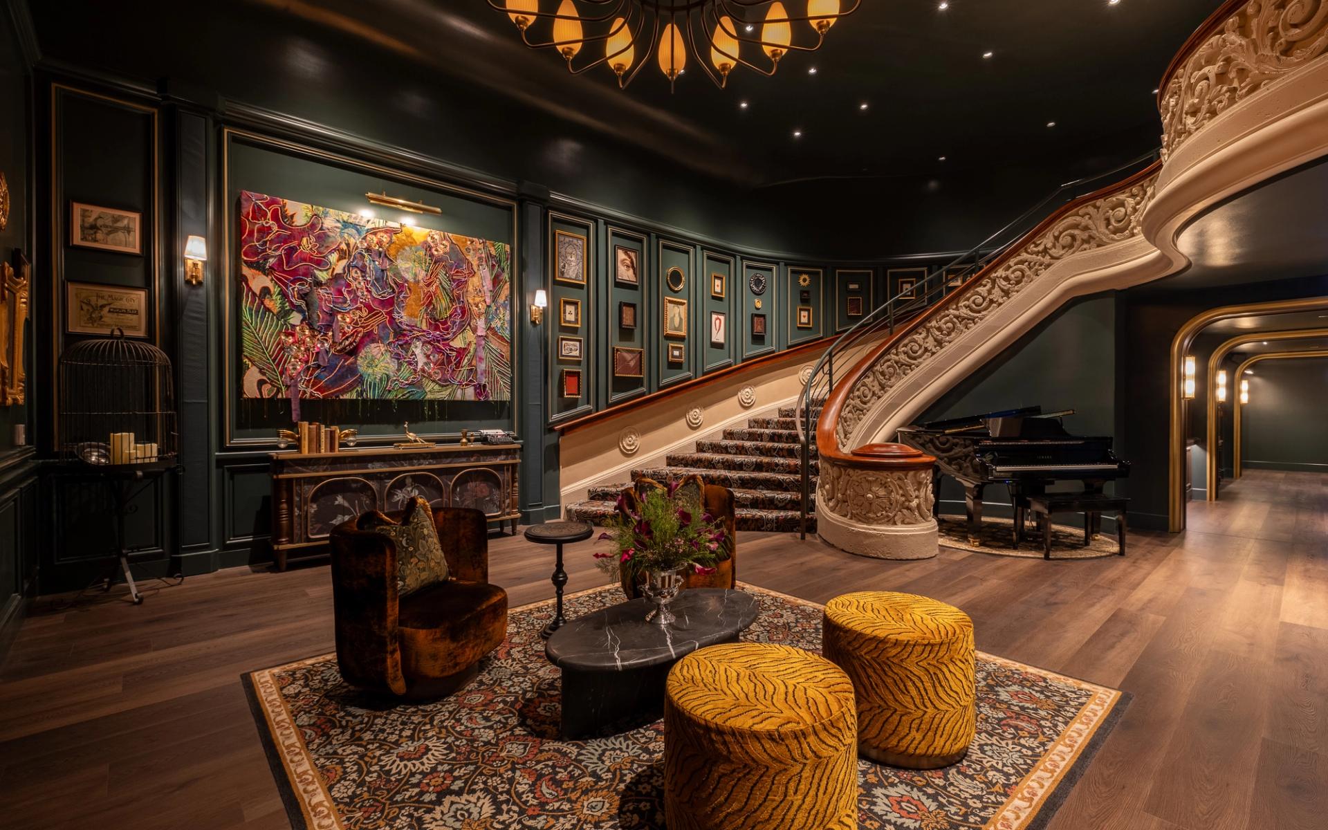 A room with green walls and an ornate staircase.