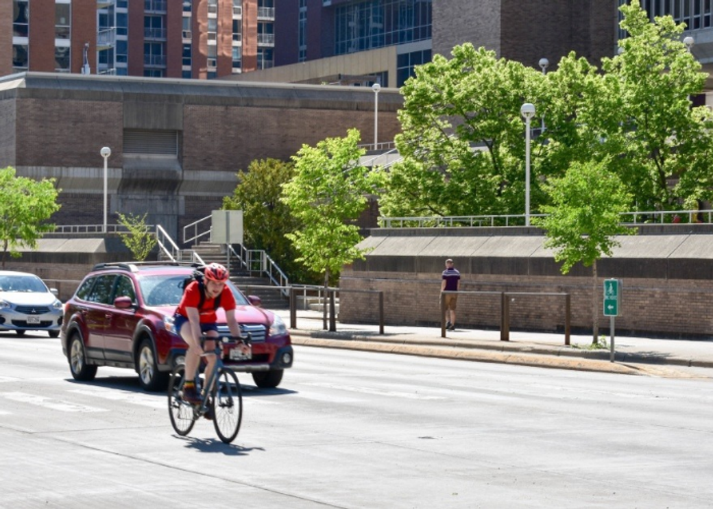 A cyclist rides on a downtown street.