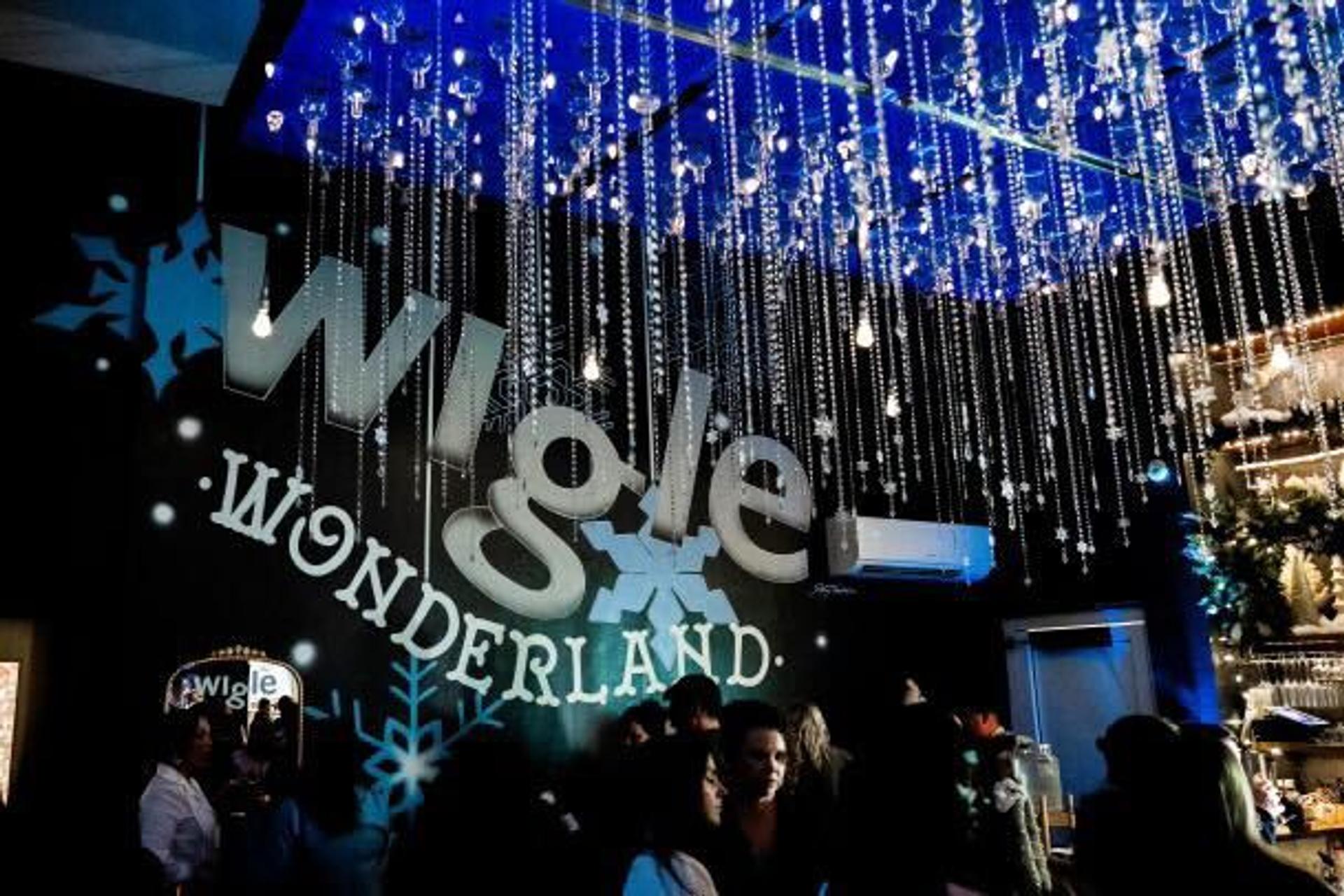 twinkling lights hang over a bar and a large sign reading "Wigle Wonderland"