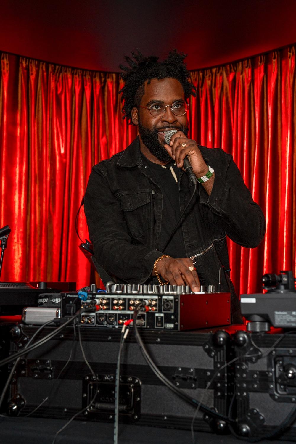 A man holding a mic behind a dj setup