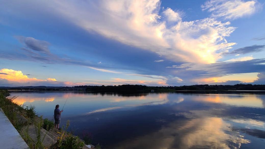 A person fishing during sunset at the Susquehanna River.