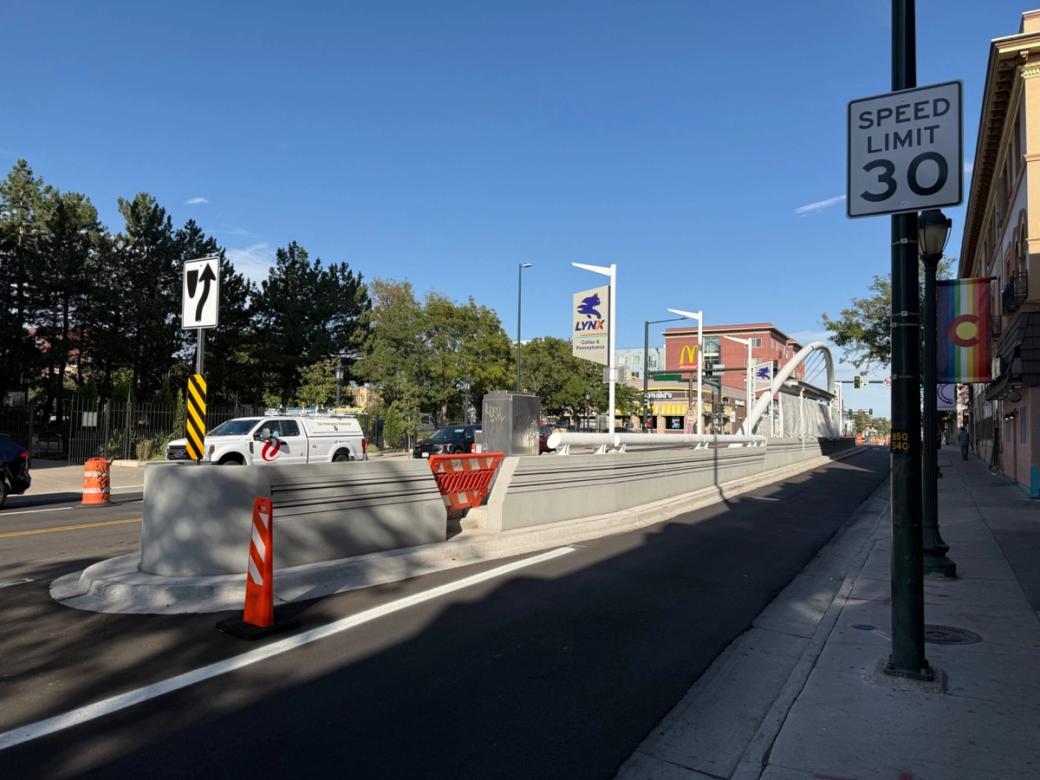 A road with a concrete median and archway above a bus station.