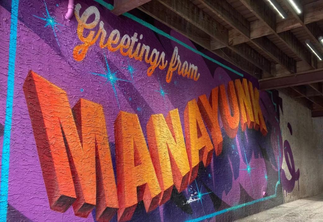 A mural that says "Greetings from Manayunk"