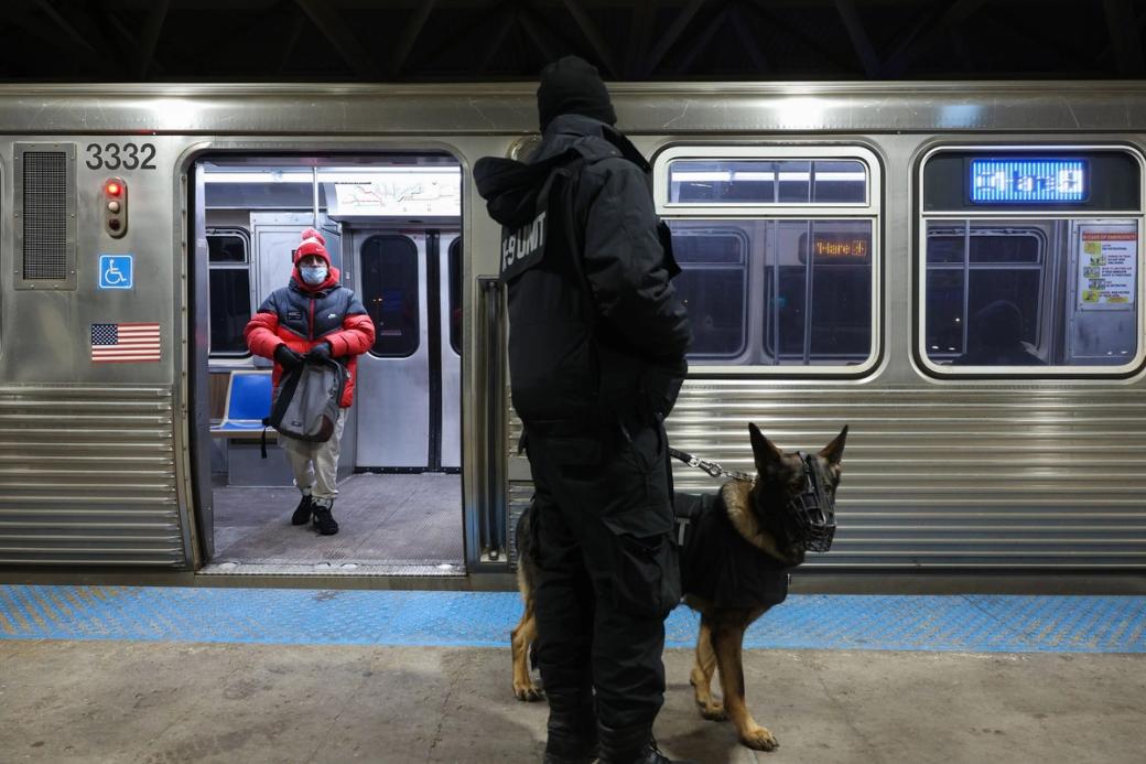 A security officer with a german shepherd by a train