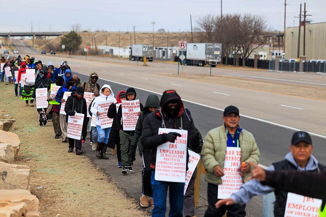 People picket outside of the JBS Foods meatpacking plant on March 16, 2026 in Greeley, Colorado.