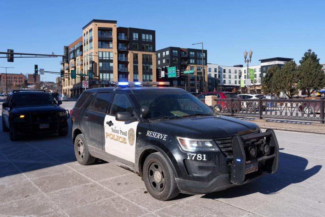 A black-and-white cop car parked with its emergency lights on. 
