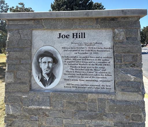 An image of a granite monument of labor activist Joe Hill in Sugar House Park.