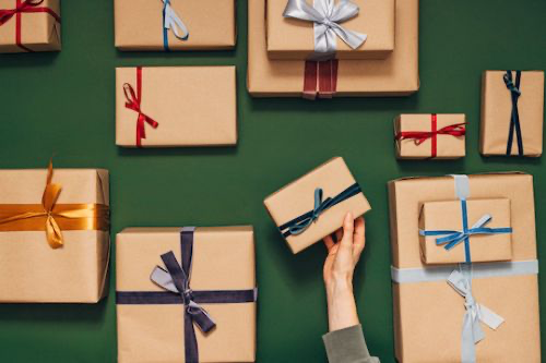 Gifts in brown paper packaging tied up with string. (miniseries / Getty)