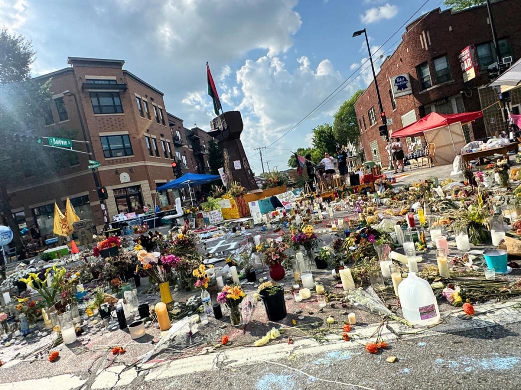 A large makeshift memorial for Corey Ruiz on a Madison street with flowers and candles.