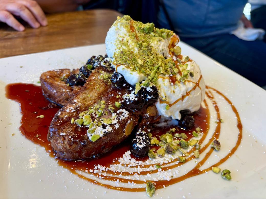 Anthos’ French toast topped with homemade fig syrup, preserved sour cherries, whipped cream, and pistachios. 