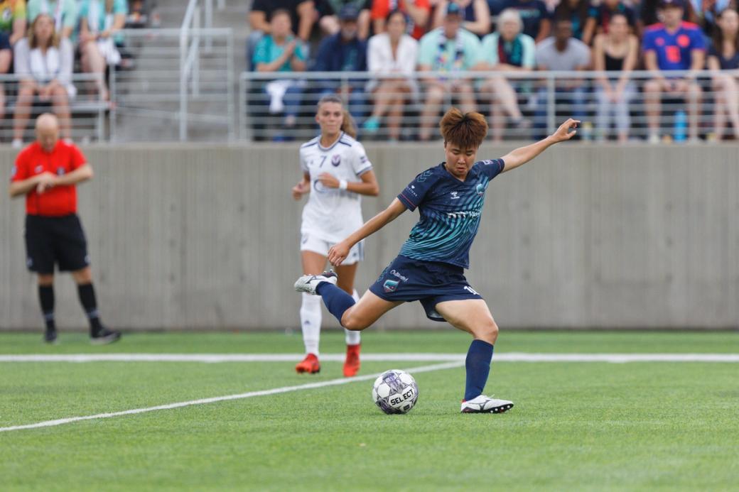 Soccer player winds up to kick ball on field