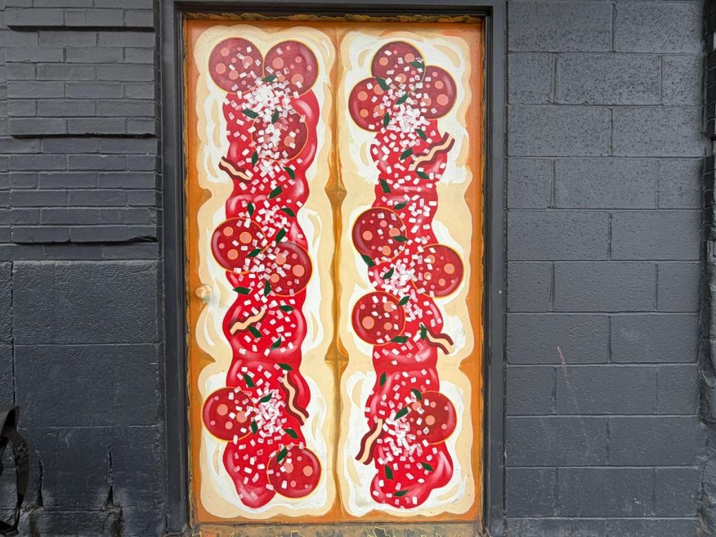 Two long pizzas painted onto a window.