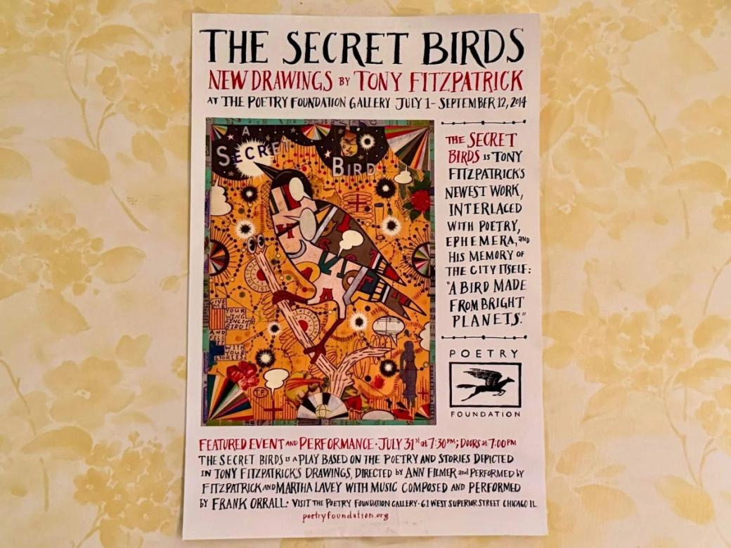 Tony Fitzpatrick poster art hung on bedroom wall that has yellow floral wallpaper