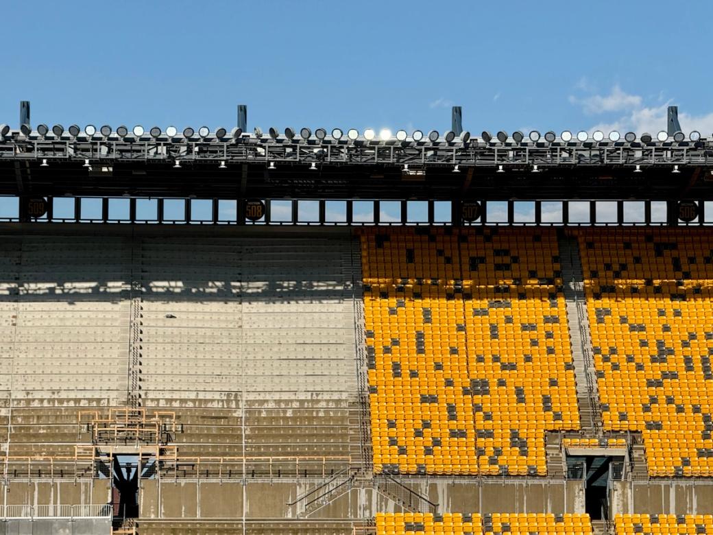 photo of stadium seats being replaced, gold on the left half of the image, yellow on the right half