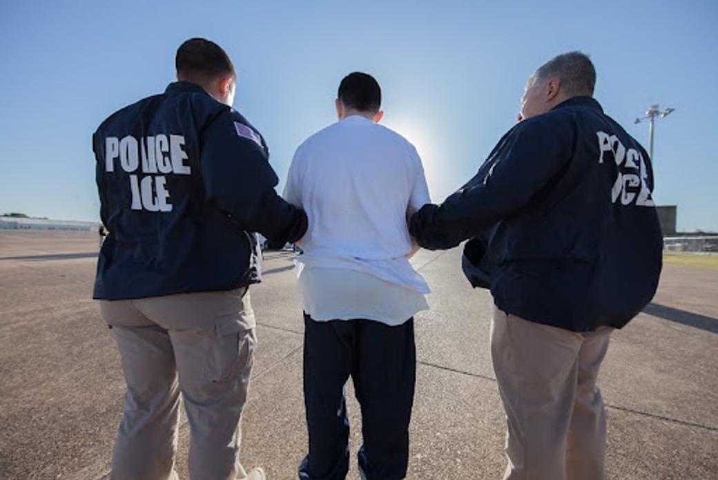 Federal agents escort a detainee